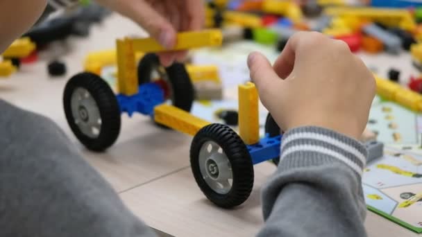 Niño juega con un kit de constructor — Vídeo de stock