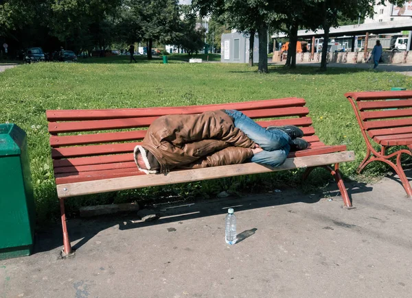 Homem sem-teto dormindo no banco — Fotografia de Stock