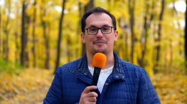 Orta yaşlı adam tv muhabiri bir rapor açar