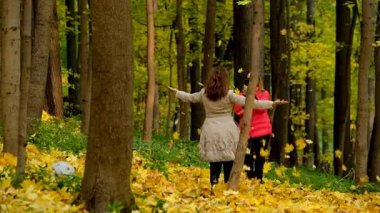 İki kız bir sonbahar Park yaprakları ve having fun at