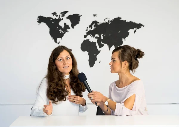 Две девочки-репортёры-близнецы ведут репортаж из белой студии — стоковое фото