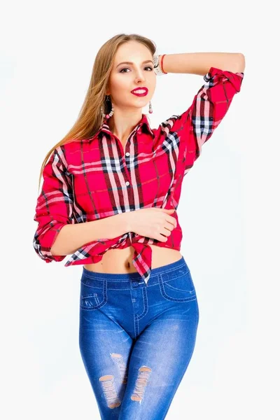 Mladá sexy žena oblečená v džínách a kostkovanou košili pózuje ve studiu — Stock fotografie