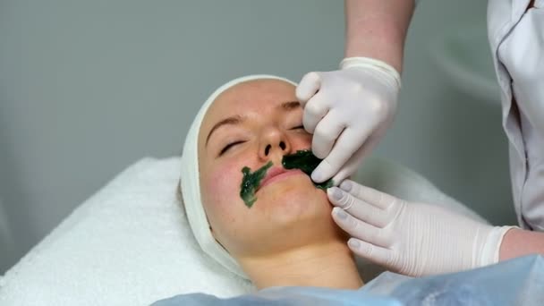 Mladá žena během procedury v kosmetologii kliniky