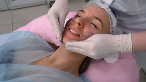 Молодая женщина во время процедуры в косметологической клинике — стоковое видео