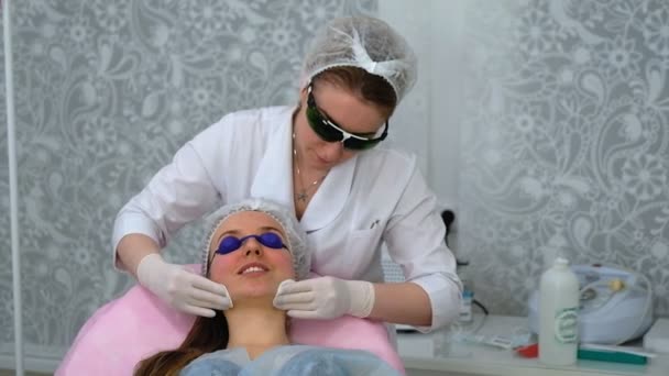 Молодая женщина во время процедуры в косметологической клинике — стоковое видео