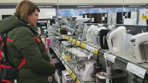 Wanita muda memilih pencampur tangan di supermarket peralatan rumah tangga — Stok Video