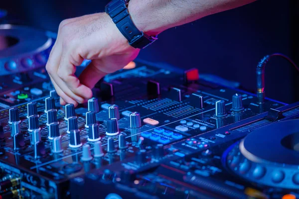 DJ toca mix no controlador em uma discoteca — Fotografia de Stock