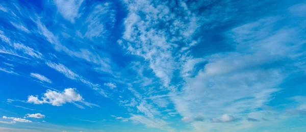 Blauwe lucht met pluizige wolken — Stockfoto