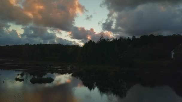 Летит дрон над озером на закате — стоковое видео