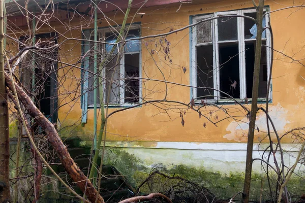 Exterior de um edifício abandonado janelas quebradas — Fotografia de Stock