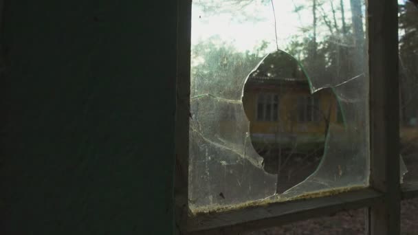 Loch im zerbrochenen Fenster des verlassenen Gebäudes — Stockvideo