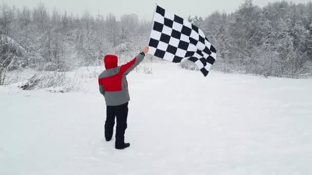 Homme agitant le drapeau d'arrivée en hiver — Video