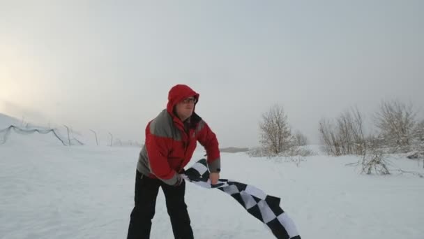 Mężczyzna macha flagą mety w zimie — Wideo stockowe