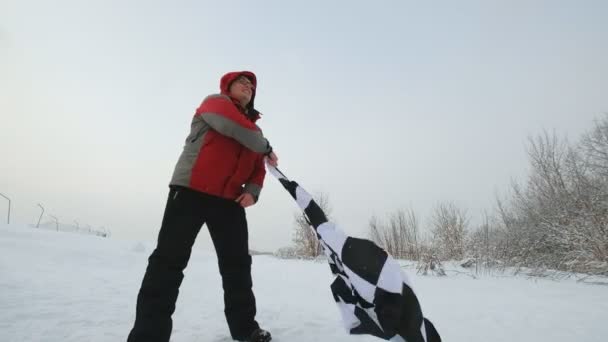 Чоловік махає фінішним прапором взимку — стокове відео