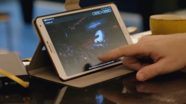Kafede tablet pc kullanarak Tesla şirket sitesi keşfetmek adam.