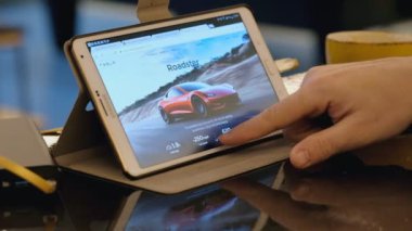 Kafede tablet pc kullanarak Tesla şirket sitesi keşfetmek adam.