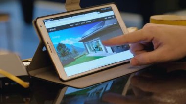 Kafede tablet pc kullanarak Tesla şirket sitesi keşfetmek adam.