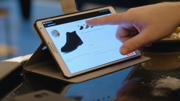 Εξερευνώντας το site της εταιρείας Tesla χρησιμοποιώντας tablet pc σε καφέ άνθρωπος. — Αρχείο Βίντεο