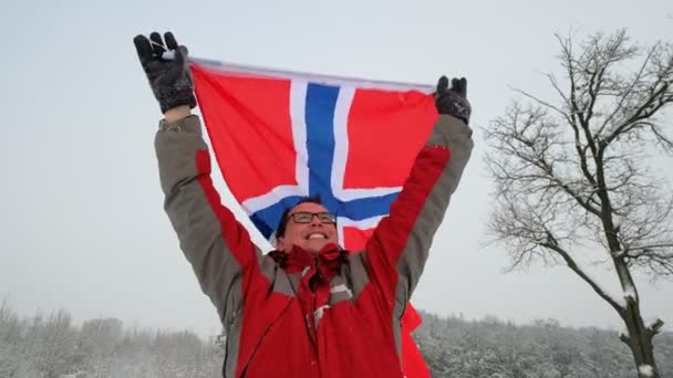 幸せな男のスポーツのファンを保持するノルウェーの旗が風になびかせて — ストック動画