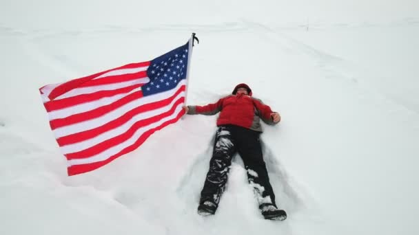 L'homme agite le drapeau américain dans la neige — Video