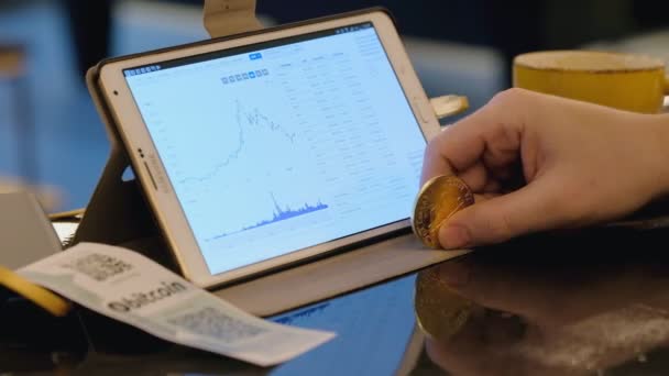 Händler Tablet-Computer bei der Arbeit, im Café. Konzept zum Bitcoin-Handel. — Stockvideo