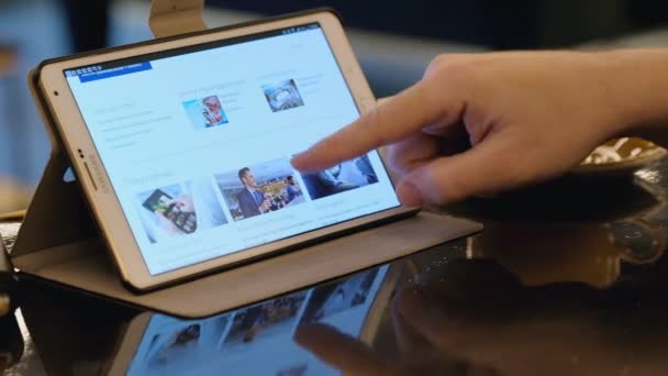 Man visita il sito della compagnia aerea americana utilizzando tablet pc in caffè . — Video Stock