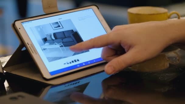 Compras en línea en el sitio web de Ikea utilizando tblet PC en la cafetería — Vídeo de stock