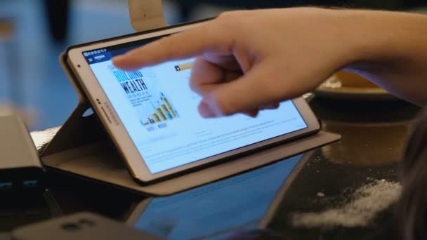 Онлайн-покупки на сайте Amazon с помощью tblet PC в кафе — стоковое видео