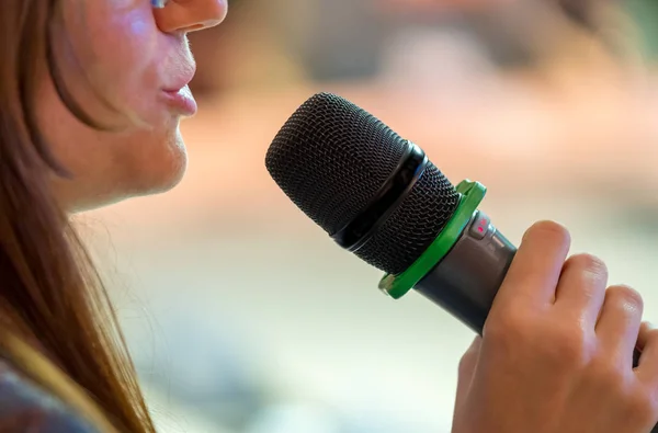 Speaker at conference holding microphone