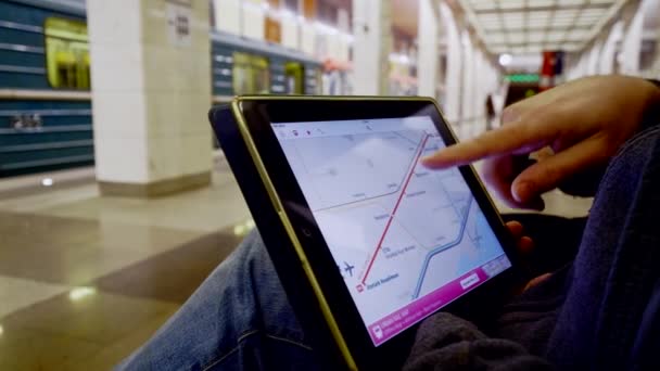 Man in ondergrondse onderzoekt de metrokaart met behulp van de tablet — Stockvideo