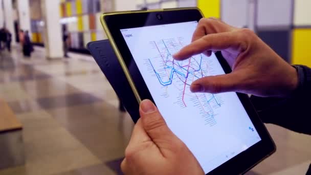 Hombre en el metro examina el mapa del metro utilizando la tableta — Vídeo de stock