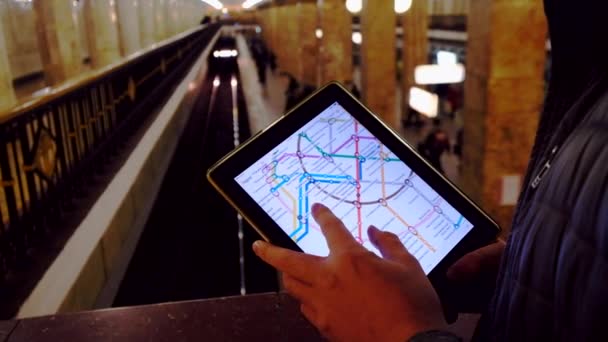 Muž v podzemí zkoumá mapa metra pomocí tabletu — Stock video