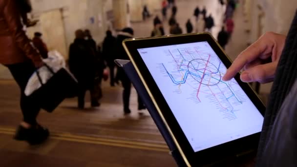 भूमिगत में आदमी टैबलेट का उपयोग करके मेट्रो मानचित्र की जांच करता है — स्टॉक वीडियो