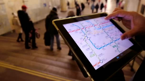Homem no subsolo examina o mapa do metrô usando o tablet — Vídeo de Stock