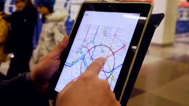 Homem no subsolo examina o mapa do metrô usando o tablet — Vídeo de Stock