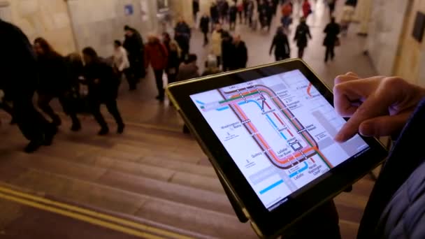Man in ondergrondse onderzoekt de metrokaart met behulp van de tablet — Stockvideo