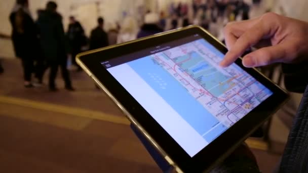 Homem no subsolo examina o mapa do metrô usando o tablet — Vídeo de Stock