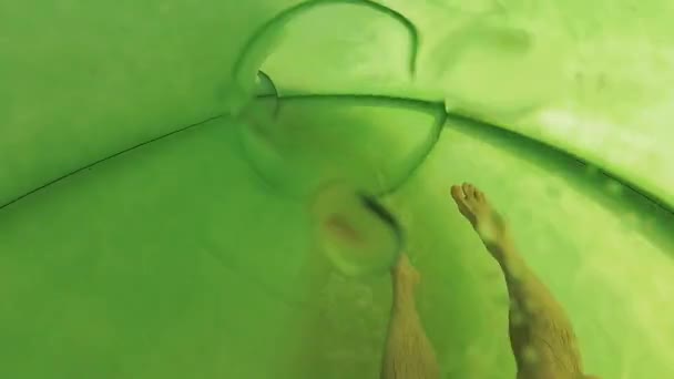 Homme glissant dans le tube au parc aquatique 