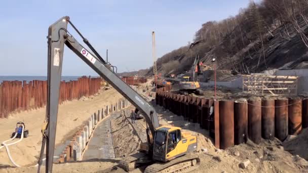 Excavator works on the seashore, strengthening the Baltic Sea coastline — Stock Video