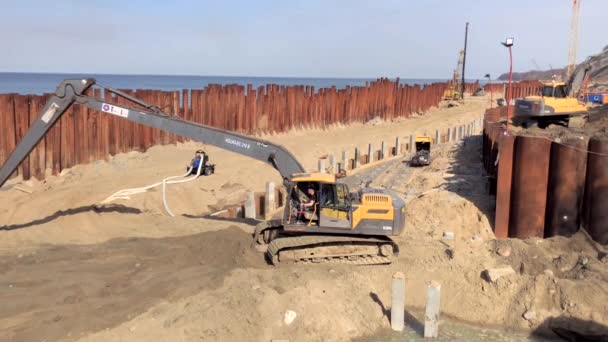 Excavator works on the seashore, strengthening the Baltic Sea coastline — Stock Video