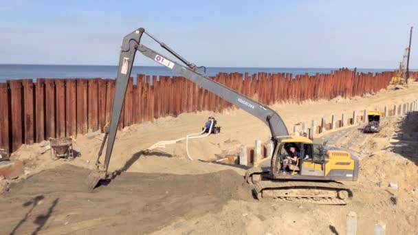 Excavator works on the seashore, strengthening the Baltic Sea coastline — Stock Video