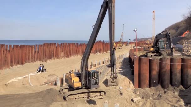 Excavator works on the seashore, strengthening the Baltic Sea coastline — Stock Video