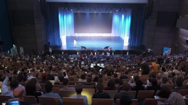 Návštěvníci fóra podnikatelského vzdělávání poslouchají přednášku ve velkém sále — Stock video