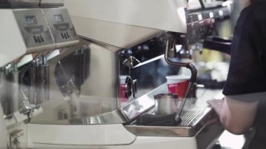 Barista kahve makinesiyle espresso yapıyor.