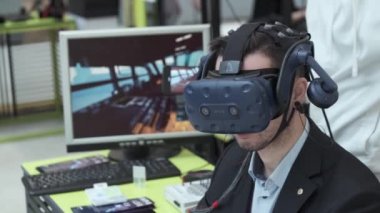 Sergi ziyaretçisi sanal gerçeklik miğferini bilgisayar oyunu için test ediyor