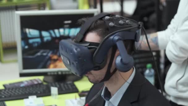 Sergi ziyaretçisi sanal gerçeklik miğferini bilgisayar oyunu için test ediyor — Stok video