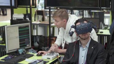 Sergi ziyaretçisi sanal gerçeklik miğferini bilgisayar oyunu için test ediyor