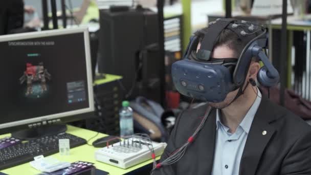 Exhibition visitor tests virtual reality helmet for computer game — Stock Video
