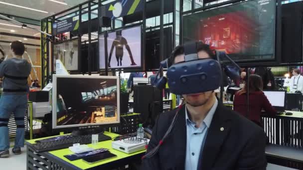 Visitante da exposição testa capacete realidade virtual para jogo de computador — Vídeo de Stock