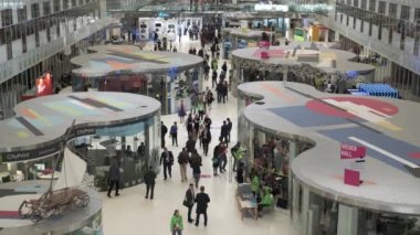 İş konferansına gelen ziyaretçiler sergi alanında dolaşıyorlar